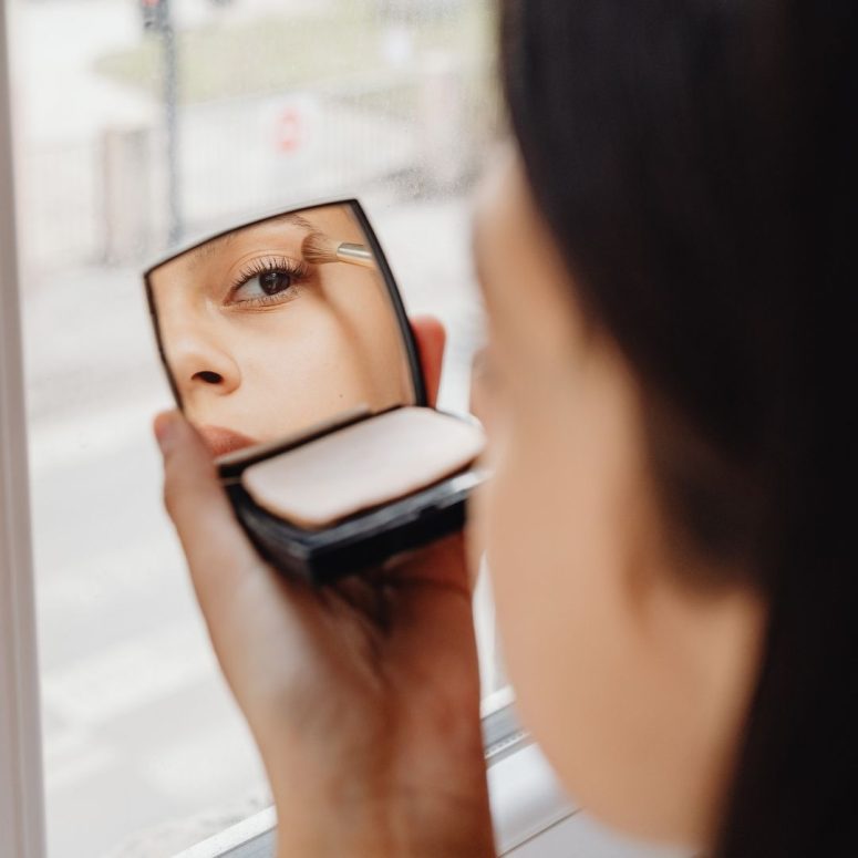 a girl is doing her make up
